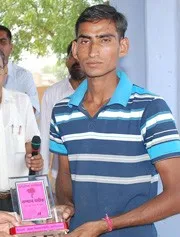 A scholarship student holding an award