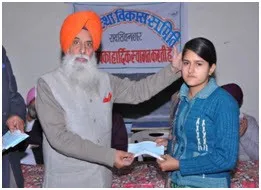 A student receives a scholarship from an India Foundation volunteer